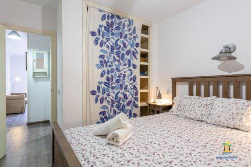 een slaapkamer met een bed en een blauwe en witte muur bij Da Paolo Apartment (in front of the beach) in Lloret de Mar