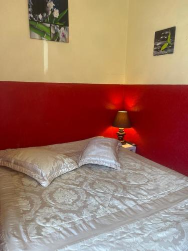 - une chambre dotée d'un lit avec un mur rouge dans l'établissement Villa in Heliovillage, Naturiste Village, South of France, au Cap d'Agde