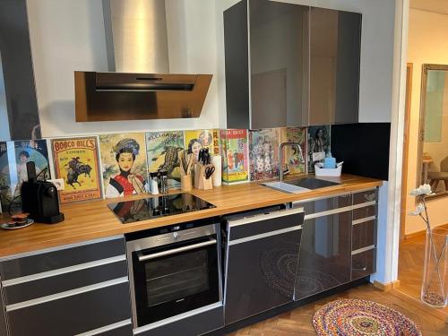 a kitchen with a counter with posters on the wall at Auszeit im Bad Diezlings in Hörbranz