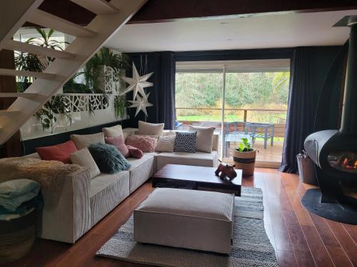 un salon avec un canapé et une table dans l'établissement villa bois sur pilotis avec vue sur forêt, à Tarnos