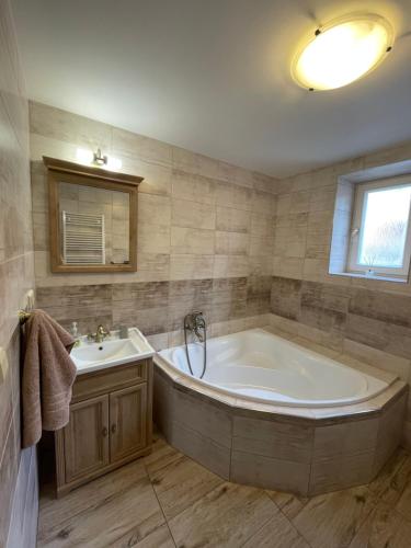 un ampio bagno con vasca e lavandino di Apartmán Kameňák a Vimperk