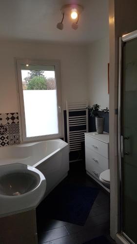 une salle de bain avec un lavabo et une fenêtre dans l'établissement villa bois sur pilotis avec vue sur forêt, à Tarnos