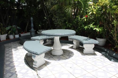a picnic table and two benches on a patio at Caribbean Tourist Villa in Port-of-Spain