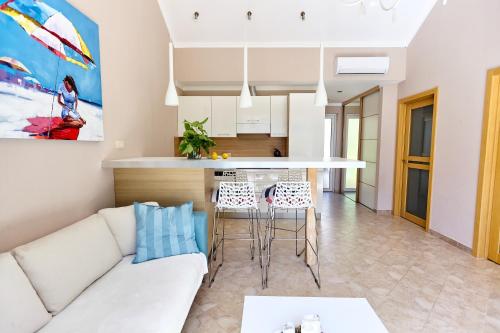 un salon avec un canapé blanc et une cuisine dans l'établissement GH Aparts with SCENIC VIEWS & POOL, à Gornji Orahovac