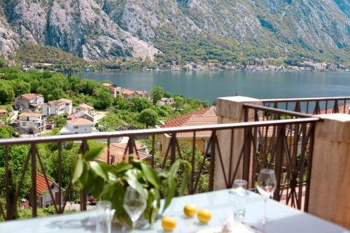 - une table avec des verres à vin sur un balcon donnant sur le lac dans l'établissement GH Aparts with SCENIC VIEWS & POOL, à Gornji Orahovac