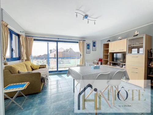 un salon avec un canapé et une table et une cuisine dans l'établissement Vue Capitainerie , Charme & Confort en Bord de Mer, à Bray-Dunes