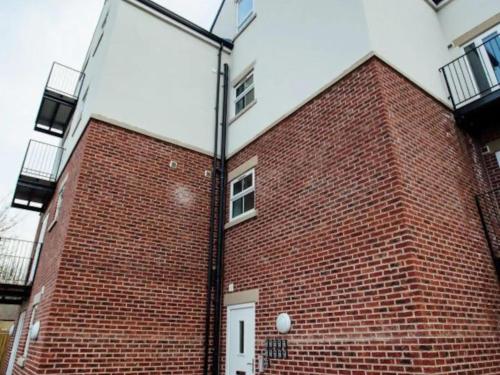 un edificio de ladrillo con una luz de la calle delante de él en 1 2 Bedroom Shield House Apartments Sheffield Centre en Sheffield