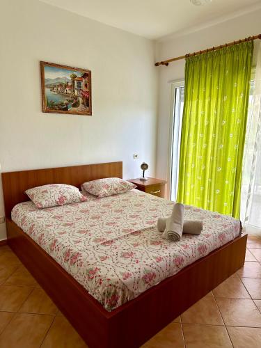 a bedroom with a bed with a green curtain at Apartment Ermest ,Kavaje Rock in Durrës
