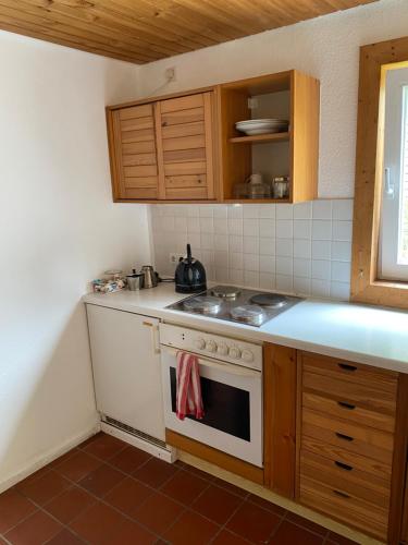 a kitchen with a white stove top oven next to a window at Grüne Oase unweit von Köln in Rösrath
