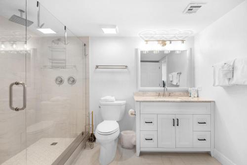 a white bathroom with a toilet and a shower at Shoreline Towers 3063 in Destin