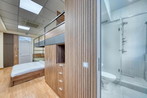 a bedroom with a bed and a shower and a toilet at Tropica Inn Hotel in Yerevan
