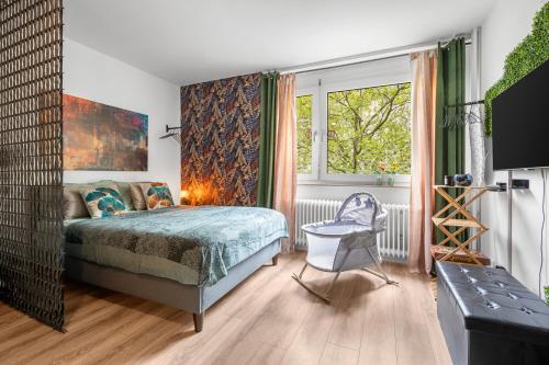 a bedroom with a bed and a chair and a window at Urban Jungle Studio Apartment in Offenbach
