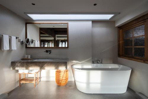 La salle de bains est pourvue d'une grande baignoire et d'un lavabo. dans l'établissement Nandu Bed&Breakfast Lijiang Ancient Town, à Lijiang