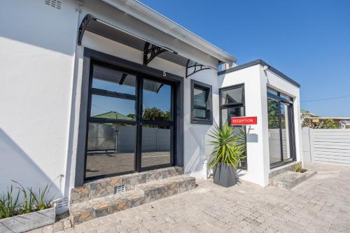 a house with black windows and a sign on it at Zuri Place in East London