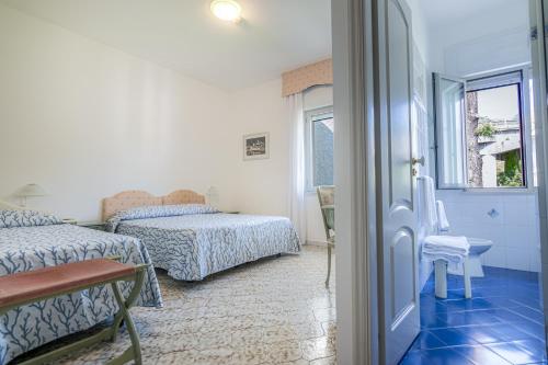 a bedroom with two beds and a window at Hotel Poseidon in Diamante
