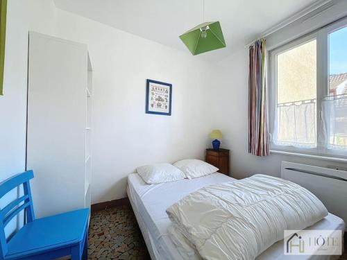 une chambre avec un lit et une chaise bleue dans l'établissement Nid Mamy: Confort, Mer, Rez-de-Chaussée, à Bray-Dunes