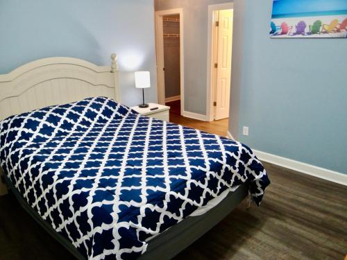 a bedroom with a bed with a blue and white comforter at The Inlet Outlet-Free Park Pass Included in Myrtle Beach
