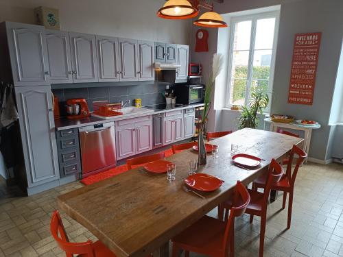 a kitchen with a wooden table with red plates on it at Charmante Maison à Coutances in Coutances