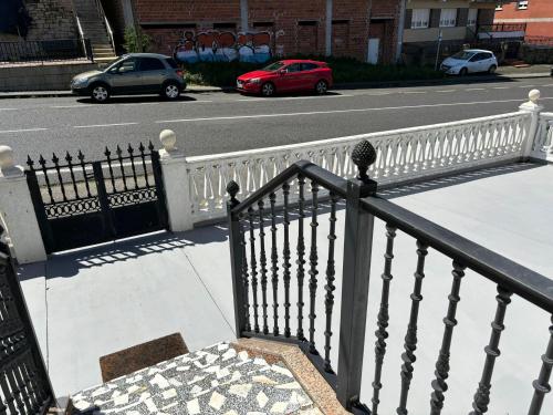 a white fence next to a street with cars at CASA DE LA NIÑA,Chalet familiar con gran terraza in Fisterra