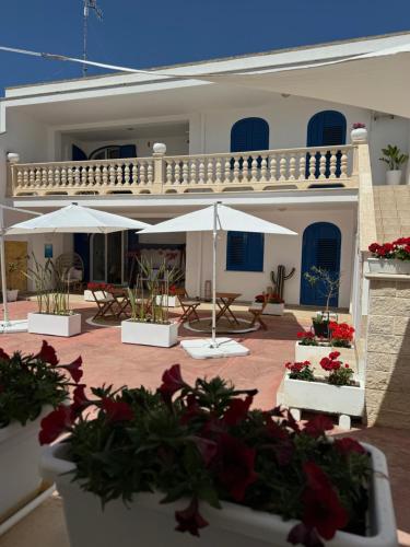 a house with umbrellas and flowers in front of it at B&B Santa Maria Di Leuca in Leuca