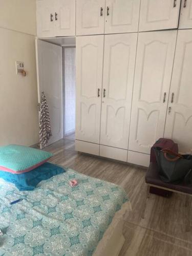 Cette chambre comprend un lit, des armoires blanches et un arbre de Noël. dans l'établissement Boho connection, à Mumbai