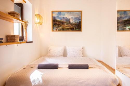 a bed in a bedroom with a painting on the wall at Dunakavics vendégház stranddal in Zebegény