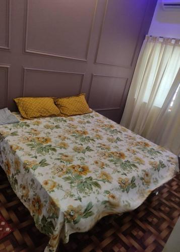 uma cama com um edredão floral num quarto em ABHIGYA HOME STAY em Faizābād