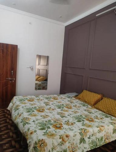 um quarto com uma cama com um edredão floral em ABHIGYA HOME STAY em Faizābād