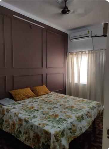 um quarto com uma cama com um cobertor floral em ABHIGYA HOME STAY em Faizābād