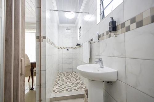 La salle de bains blanche est pourvue d'un lavabo et de toilettes. dans l'établissement Safi 1 bedroom Suite 9, à East London