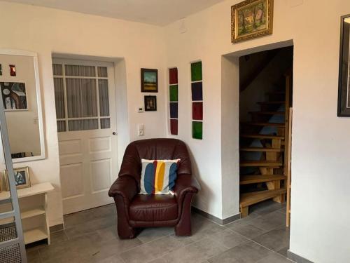 a brown chair with a pillow in a room at Ferienhaus mit Garten in Thermennähe in Strebersdorf