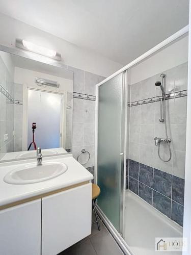 une salle de bain blanche avec un lavabo et une douche dans l'établissement Horizon Sérénité Vue Mer, 2e Étage Confort, à Bray-Dunes