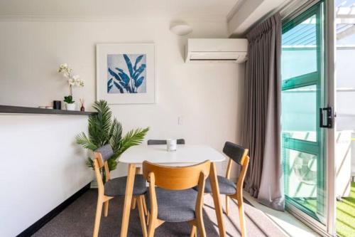 een eetkamer met een witte tafel en stoelen bij Welcome To Your Secluded Luxury Abode in Auckland