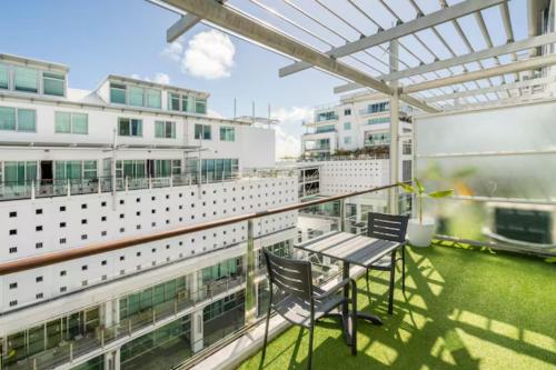 a balcony with a table and chairs on a building at Welcome To Your Secluded Luxury Abode in Auckland