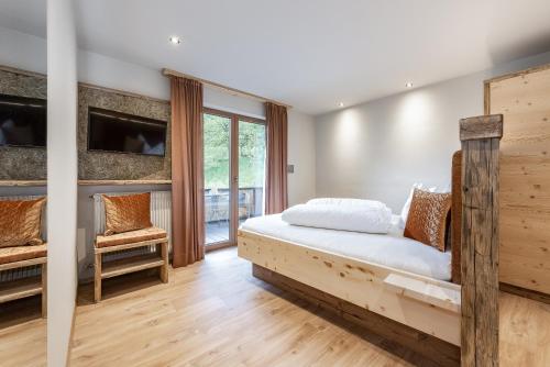 a bedroom with a wooden bed and a tv at Mirabelle Pension Sankt Ursula in Saltusio