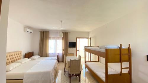 ヴロラにあるAPARTAMENT RADHIMEのベッド2台と二段ベッドのある寝室