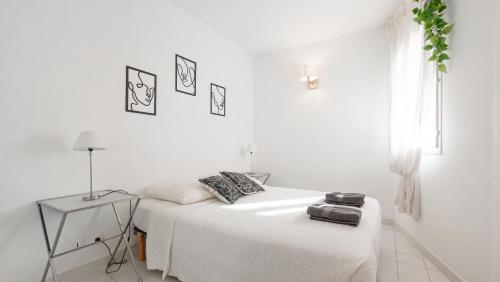 a white bedroom with a bed and a table at CASA NOSTRA, Port-Grimaud, Vue sur les Canaux in Grimaud