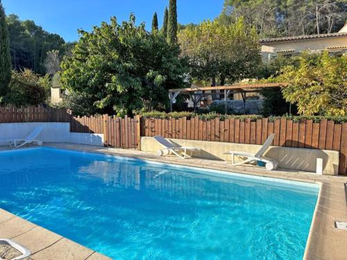 une piscine avec deux chaises et une clôture dans l'établissement Parenthèse nature, à Lorgues