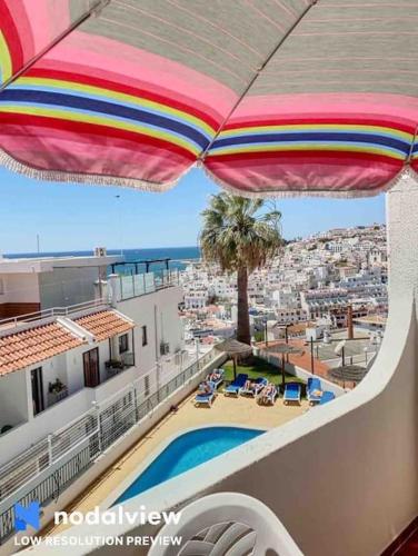 a view of a balcony with an umbrella and a pool at Silmaria Sea View amazing in Albufeira