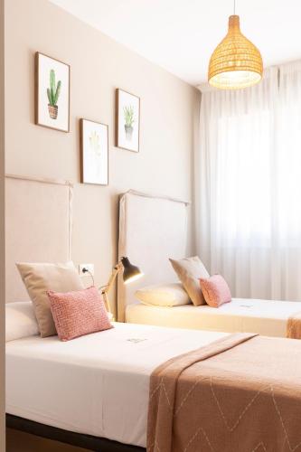 two beds in a room with white walls at Apartamentos Martalia Áticos Deluxe in Ronda