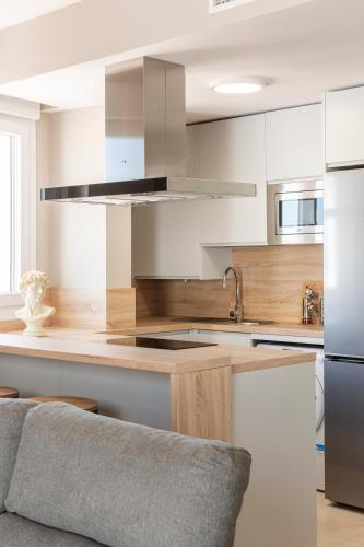 a kitchen with white cabinets and stainless steel appliances at Apartamentos Martalia Áticos Deluxe in Ronda