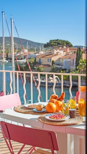 une table avec de la nourriture et des boissons sur un balcon dans l'établissement CASA NOSTRA, Port-Grimaud, Vue sur les Canaux, à Grimaud
