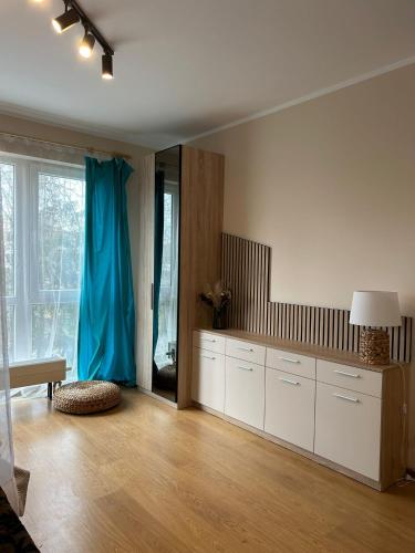 een woonkamer met een grote kamer met een blauw gordijn bij Saulkrastu nams in Zvejniekciems