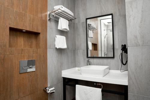 a bathroom with a sink and a mirror at Port Rivoli Baku Luxury Boutique Hotel in Baku