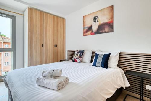une chambre avec un grand lit blanc avec des serviettes dessus dans l'établissement appartement idéalement situé sur aix en provence, à Aix-en-Provence