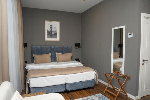 a bedroom with a bed with a blue headboard at Port Rivoli Baku Luxury Boutique Hotel in Baku