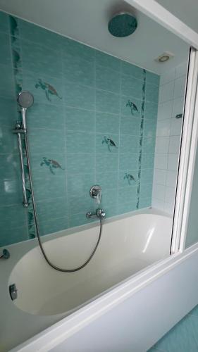 a bath tub with a shower with dolphins on the wall at Emporium Apartments in Rēzekne