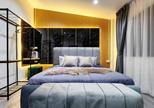 um quarto com uma cama grande e uma parede amarela em LS 3 Lasalle House,bts,Suvarnabhumi ,mega bangna em Bangkok