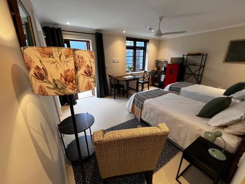 a bedroom with two beds and a lamp and a table at Aloe Studio in Cape Town