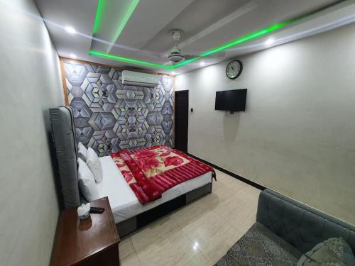um quarto com uma cama, uma televisão e um sofá em Stunning Apartment/Guest House em Islamabad